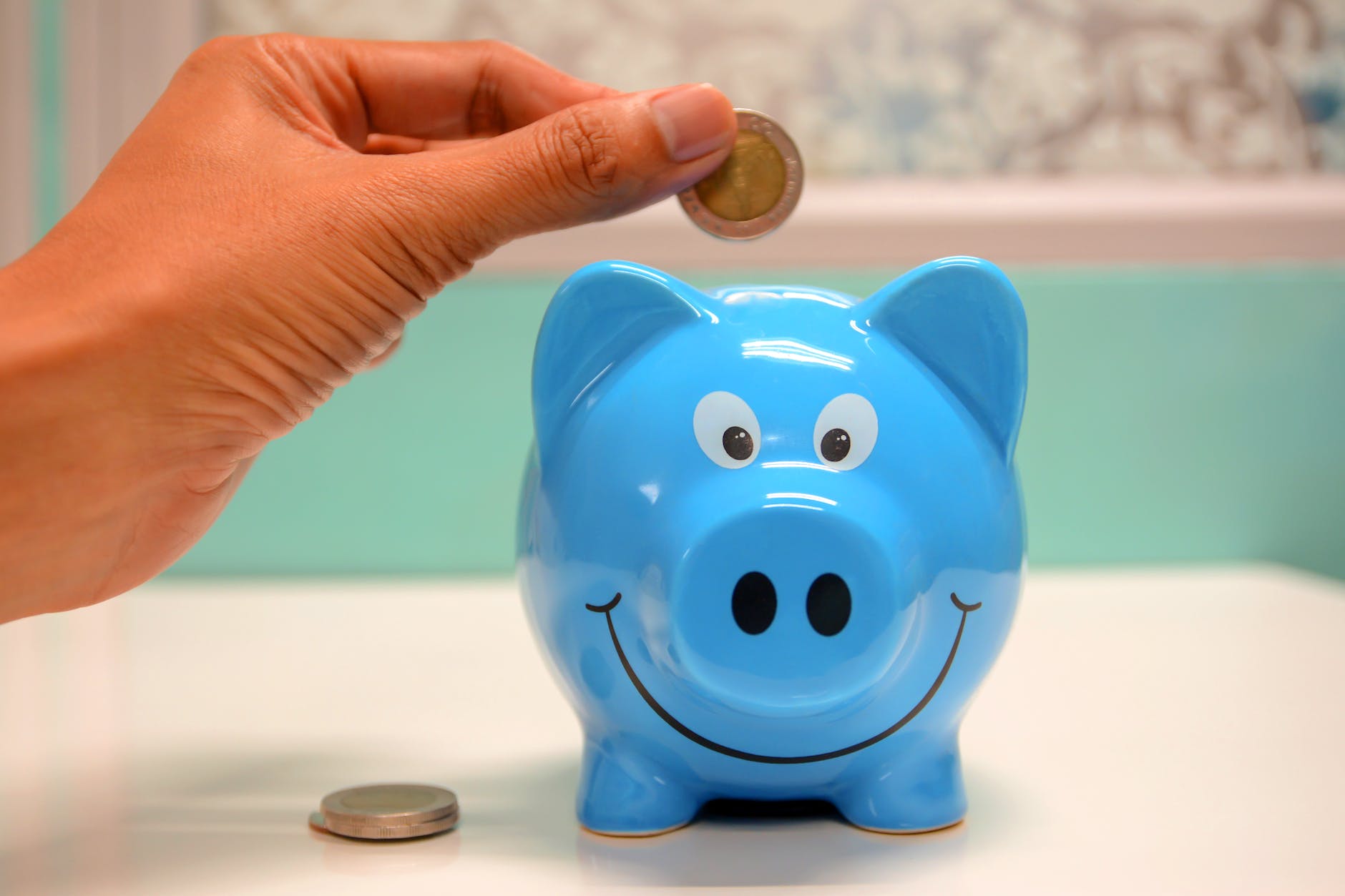 person putting coin in a piggy bank making money blogging as a doctor