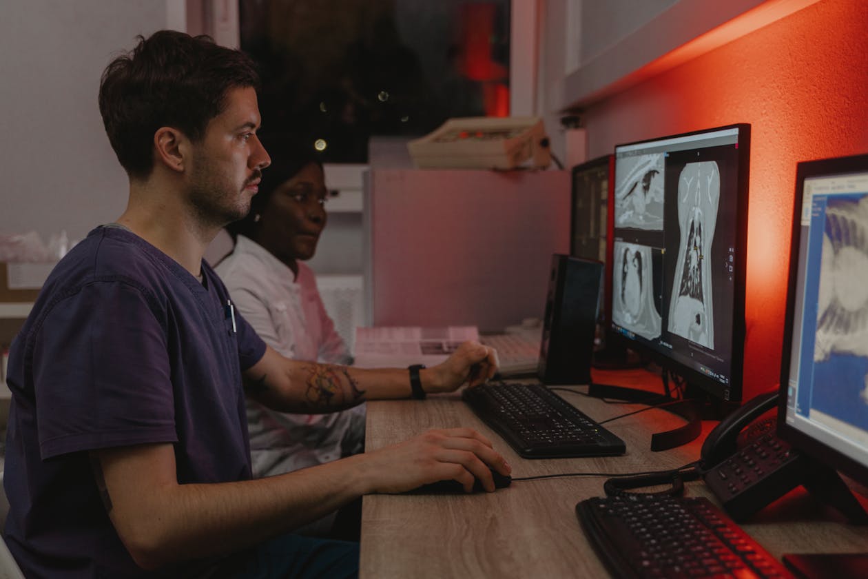 Two healthcare professionals working at radiology workstations