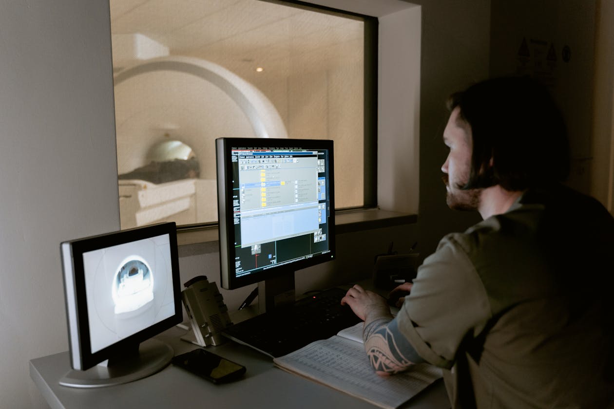 Radiologist examining MRI scans on computer monitors